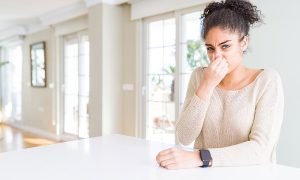 Nasal congestion and allergic symptoms in a young woman indoors, Poor indoor air quality concept.