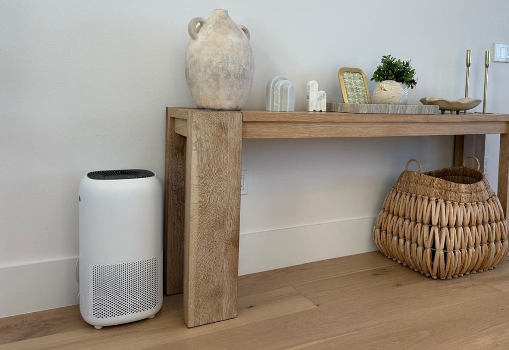 Portable air purifier on a wooden floor in a modern living space, Enhances air quality and air purification.