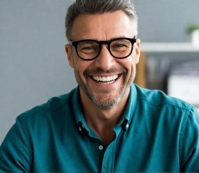 Happy Customer at TrustedAir Smiling middle-aged man with glasses in a professional setting, representing trusted HVAC services.