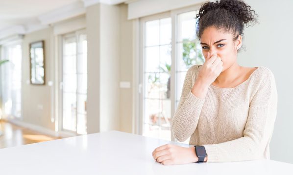 girl holding nose in smelly housue